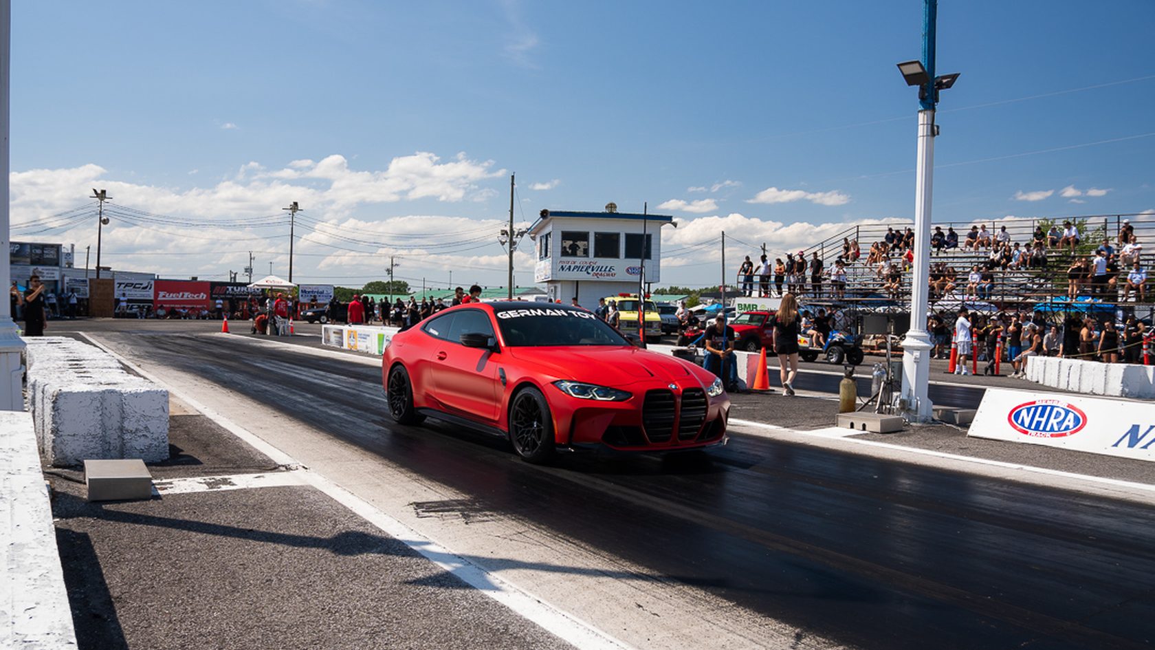 A red BMW M4 staged at the startline